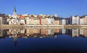 View of riverside Lyon, with the town's pretty waterside buildings reflected in the water